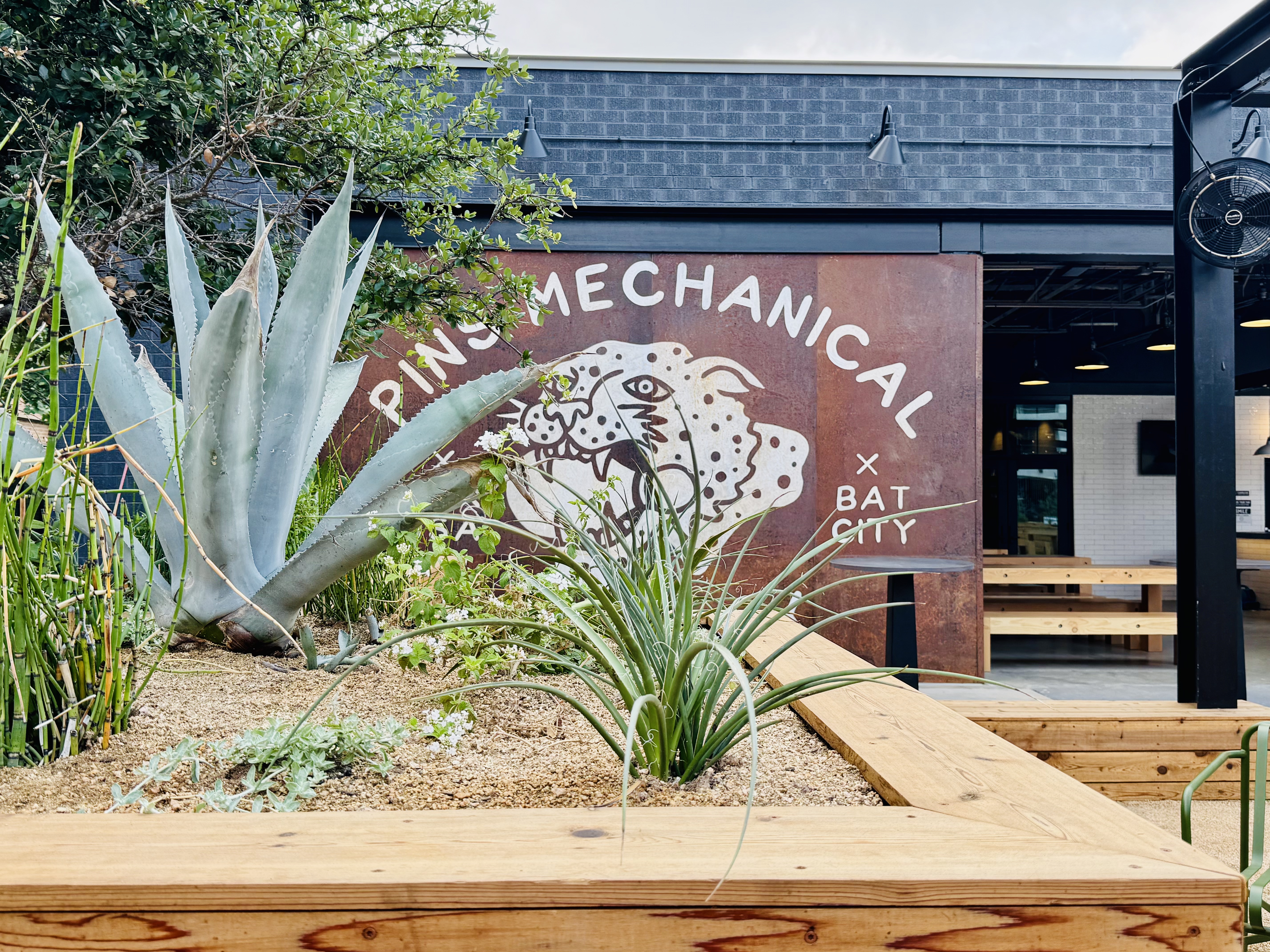 Agave, horsetail and red yucca in front of the corten Pins Mechanical panel